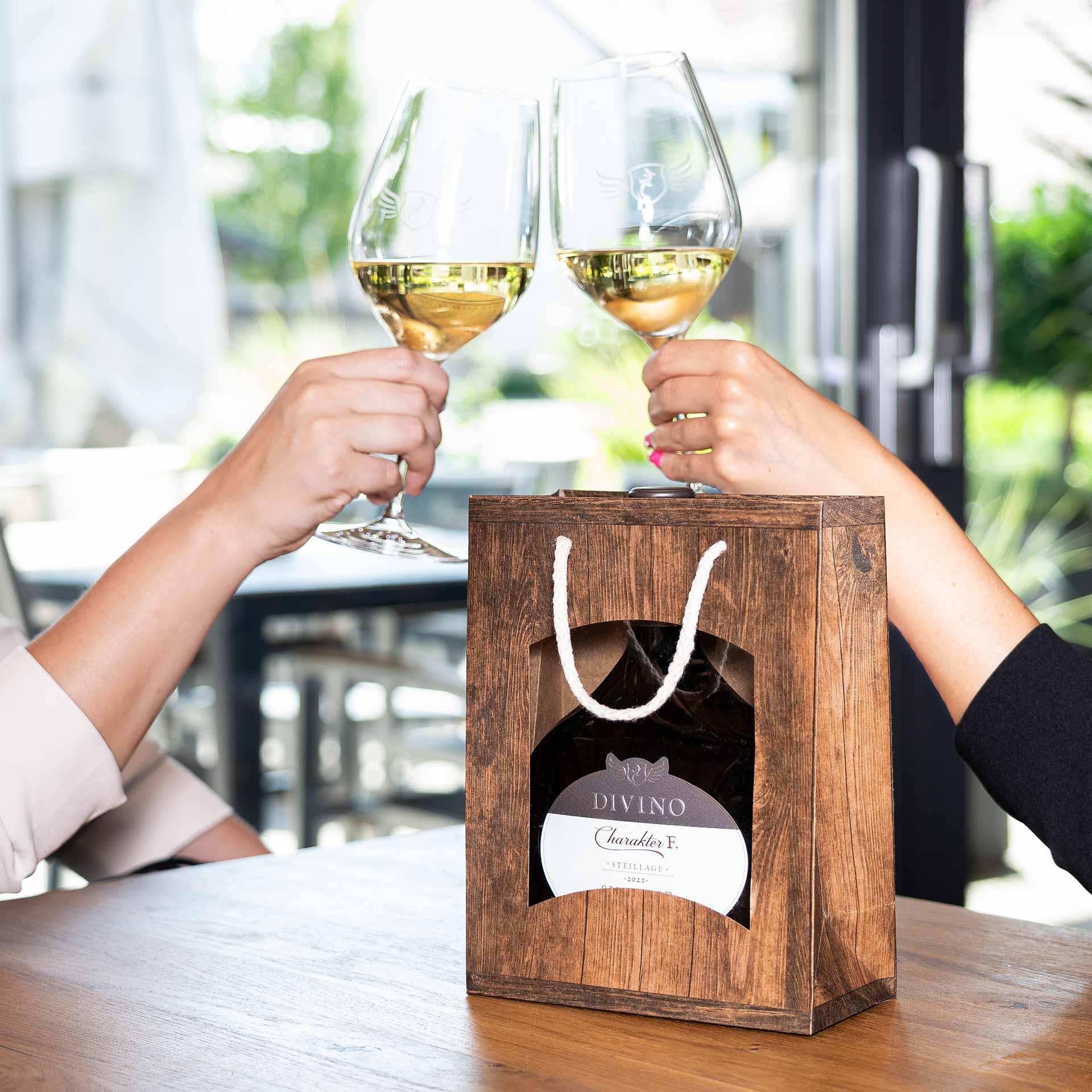 Geschenktüte mini Bocksbeutel gefüllt mit anstoßenden Personen an einem Tisch