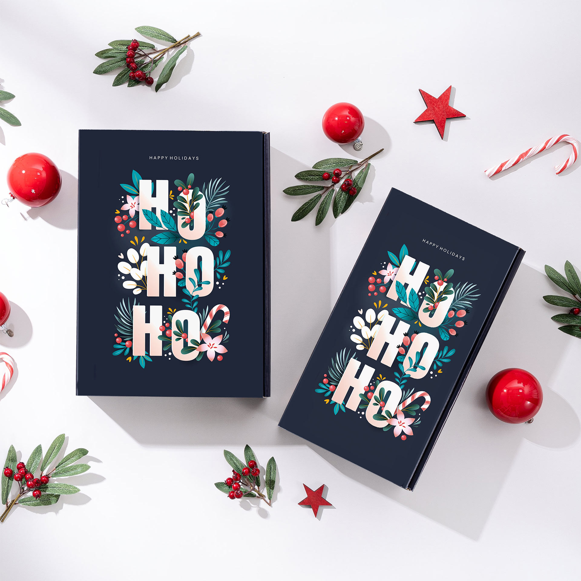 Zwei Geschenkverpackungen mit dem Design Hohoho mit weihnachtlichen Elementen