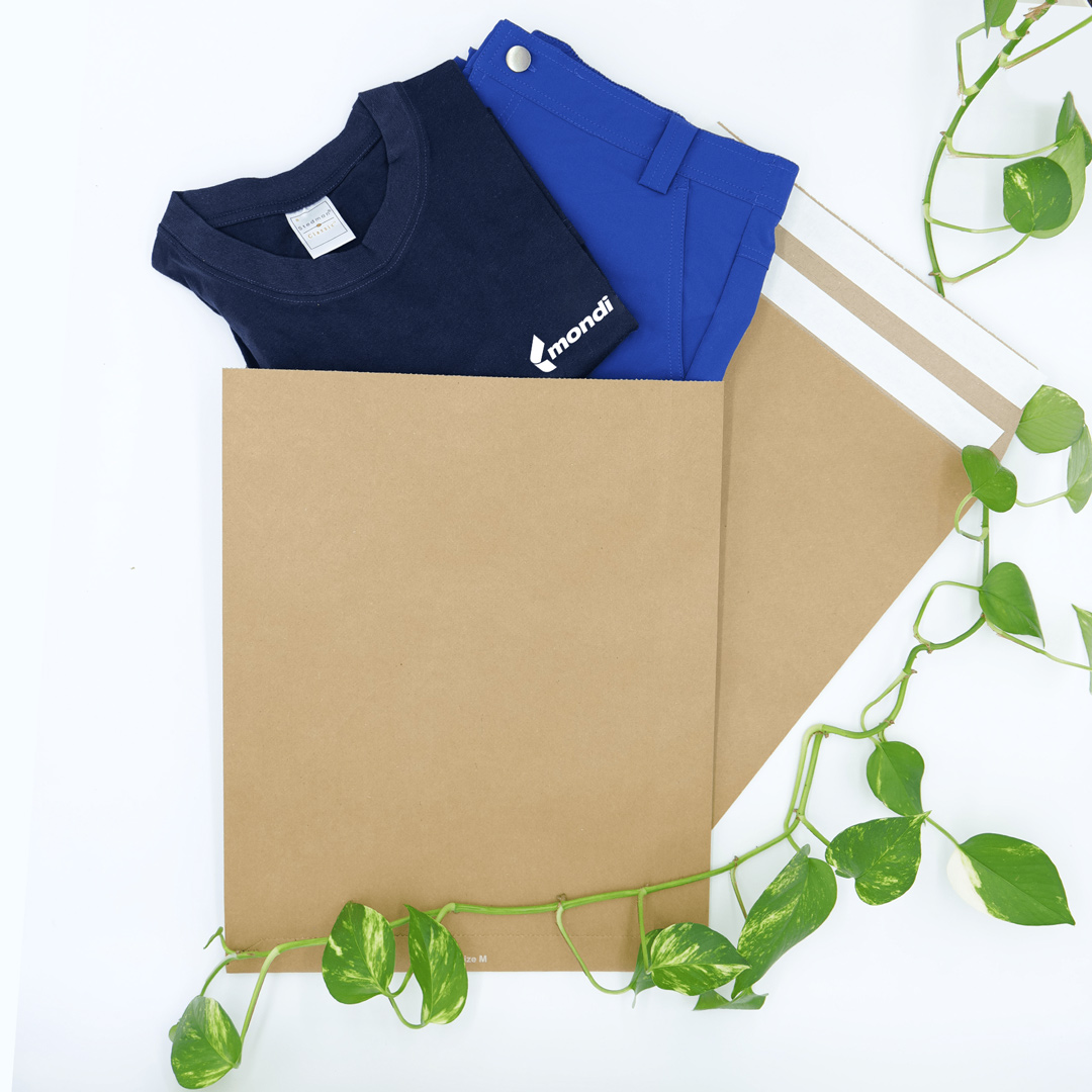 Versandtaschen aus Papier mit einem blauen Tshirt und Hose und einer Pflanze