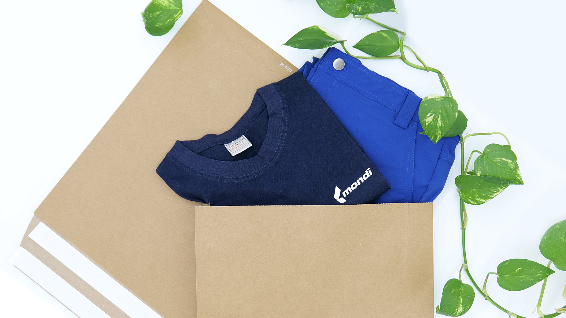 Versandtaschen aus Papier mit einem blauen Tshirt und Hose