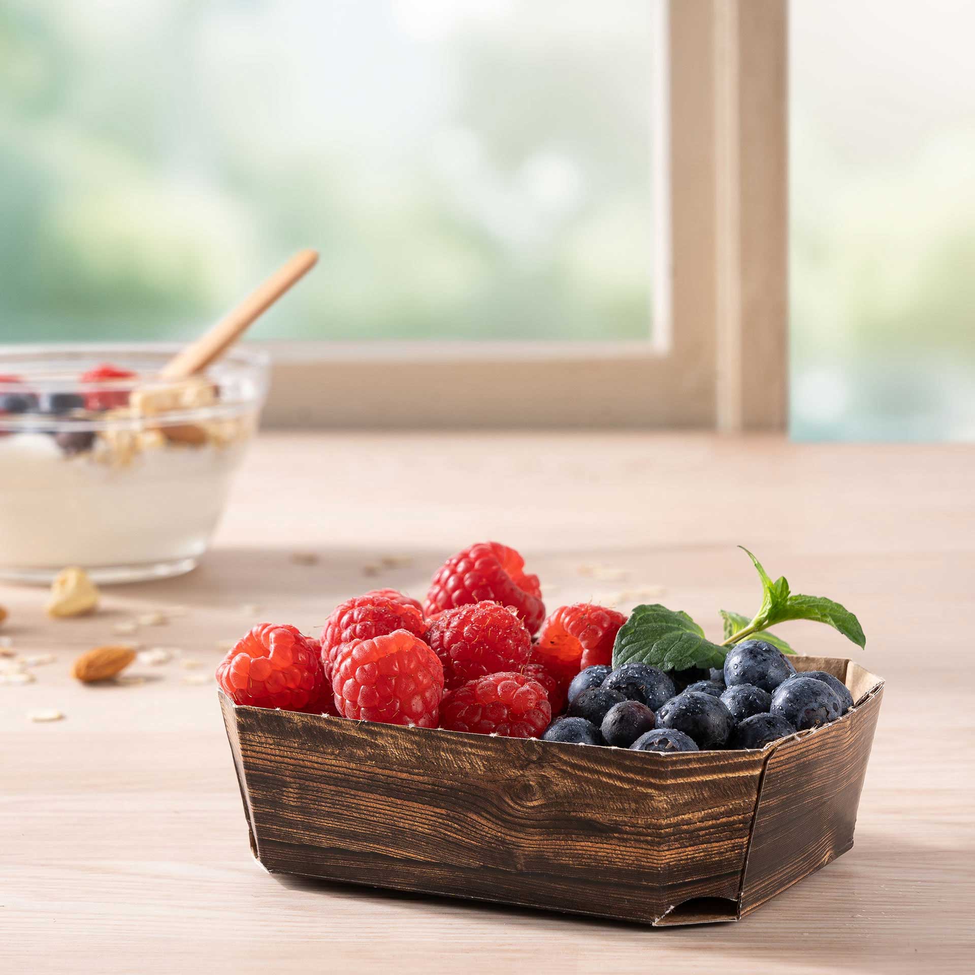 Eine Beerenschale 125g mit Himbeeren und Blaubeeren auf einem Tisch