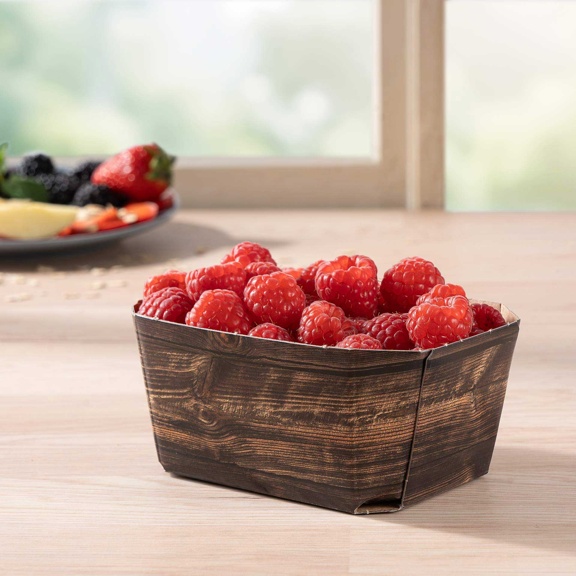 Eine Beerenschale 250g mit Himbeeren auf einem Tisch
